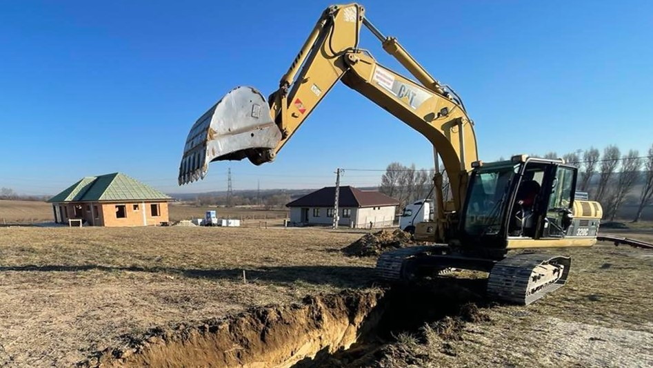 Lánctalpas kotró földet emel ki egy árokból