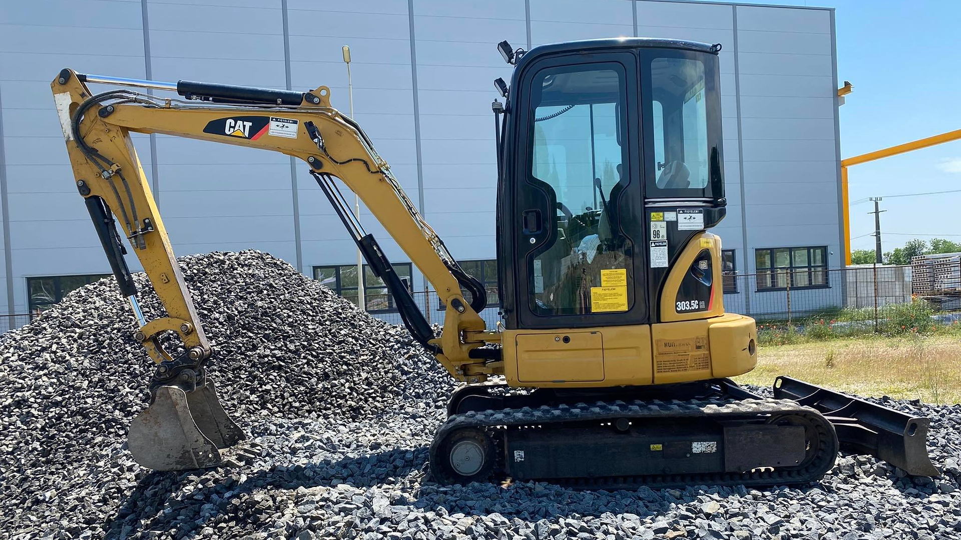 CAT 303.5C minikotró zúzottkő halom mellett